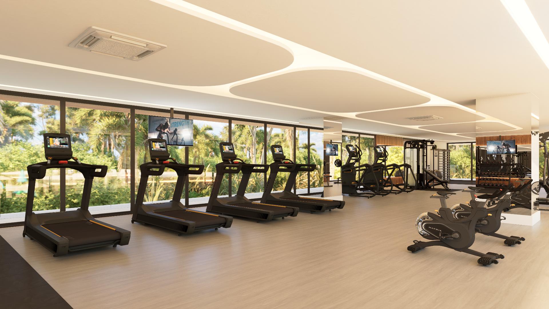 Academia climatizada do L'essence, com esteiras e bicicletas voltadas para o jardim